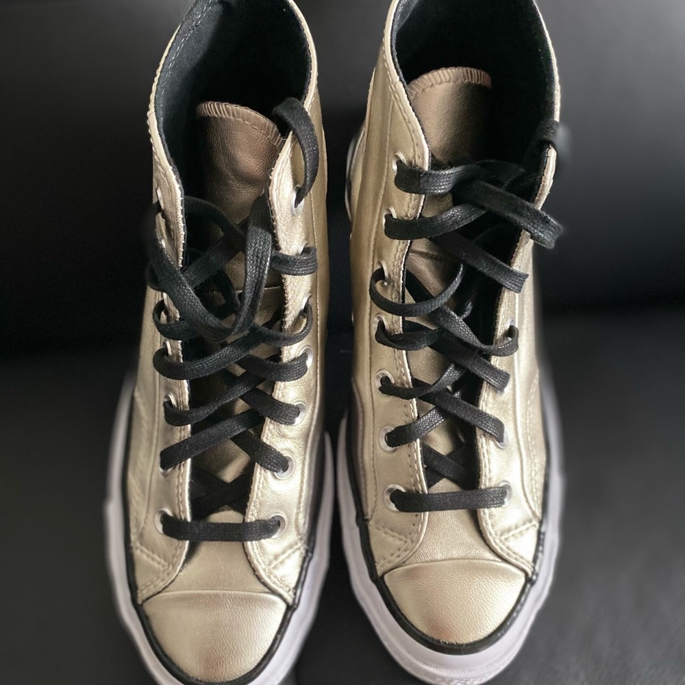 Converse gold high tops.